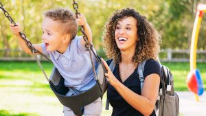 Mother pushing son on swing